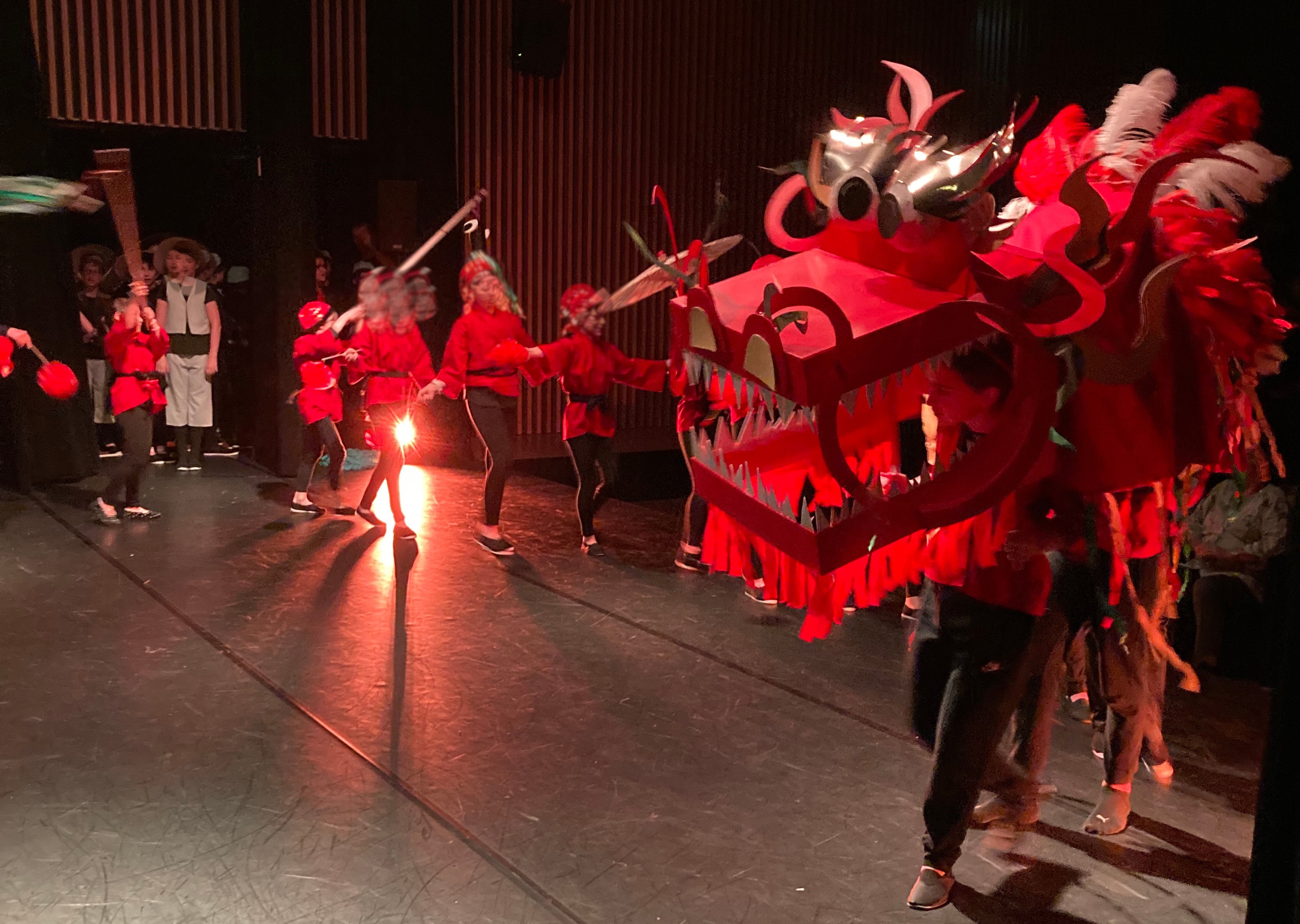 des enfants sur scènne anime un dragon